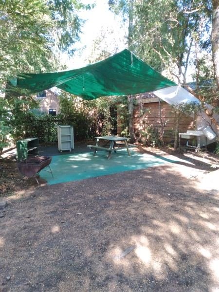 Sitio de camping equipado con toldo, mesón y parrilla